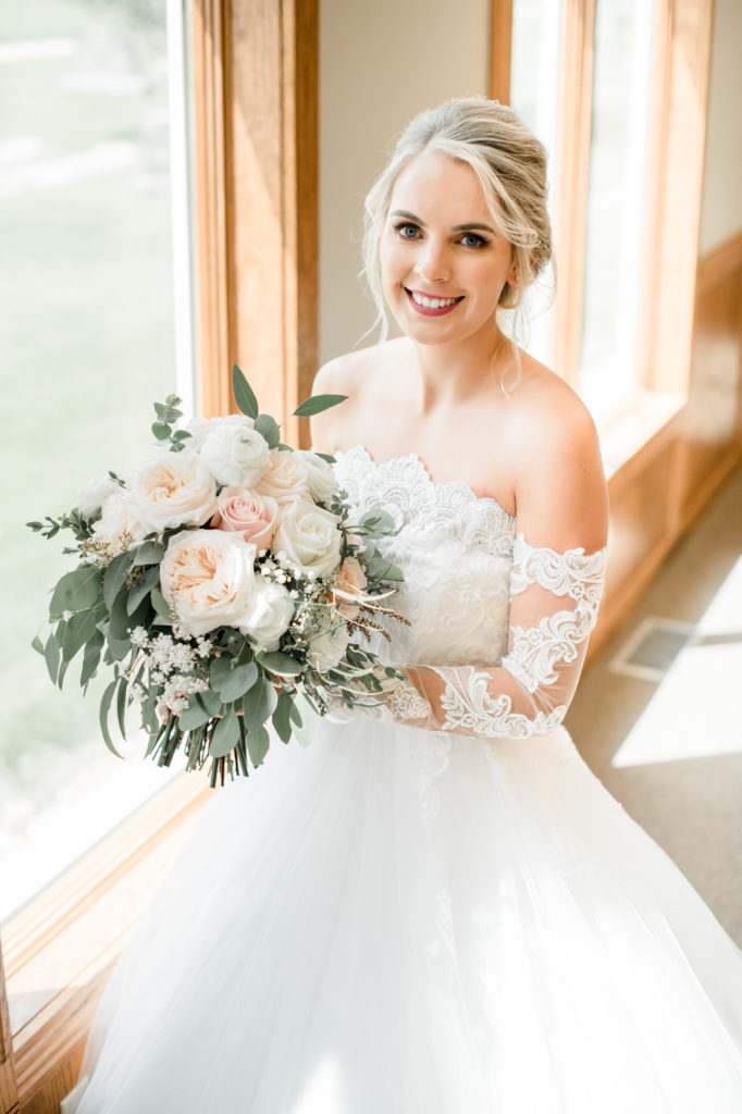 Bride with flowers by window