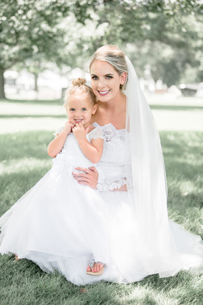 Bride with flower girl outside