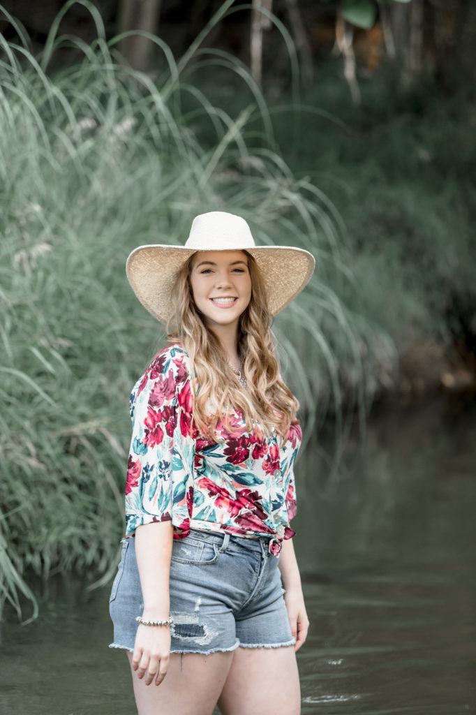 senior photography in river with hat