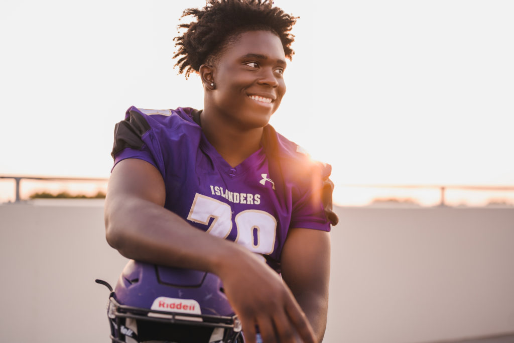 how to choose a senior photographer, young African American man in football uniform