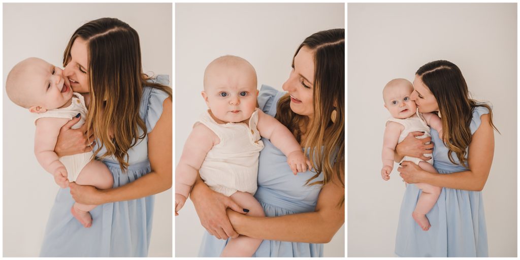 6 month photography of baby boy in white jumper being held by mom